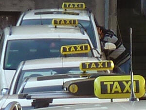 Bild vergrößern: Mehrere Taxen stehen hintereinander an einem Taxistand.