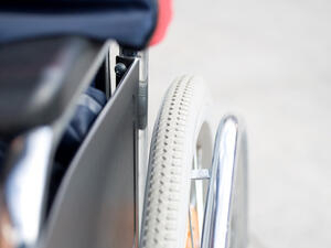 Bild vergrößern: Armlehne und Reifen eines Rollstuhles.