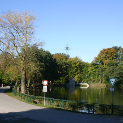 Bild vergrößern: Asphaltierter Radweg entlang eines Teichs.