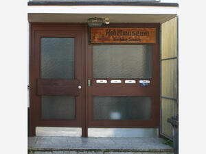 Bild vergrößern: Ein Schild mit der Aufschrift "Hobelmuseum. Gerhard Schmitz." hängt an einer Tür.