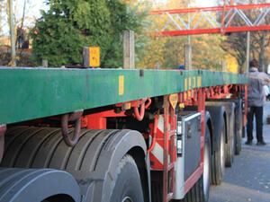 Bild vergrößern: Ein Schwerlasttransporter steht an einem Straßenrand.