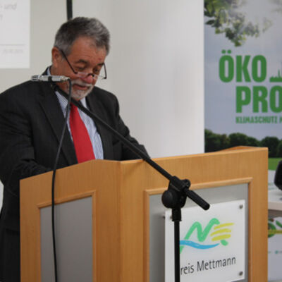 Bild vergrößern: Ein Mitarbeiter des Umweltministerium NRW steht an einem Rednerpult. Im Hintergrund ein Aufsteller des Ökoprofit Kreis Mettmann.