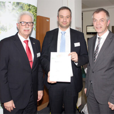 Bild vergrößern: Landrat Thomas Hendele und Minister Johannes Remmel übergeben einer männlichen Person eine Urkunde.