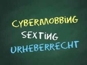 Bild vergrößern: Auf einer Tafel stehen die Schlagworte "Cybermobbing", "Sexting" und "Urheberrecht".