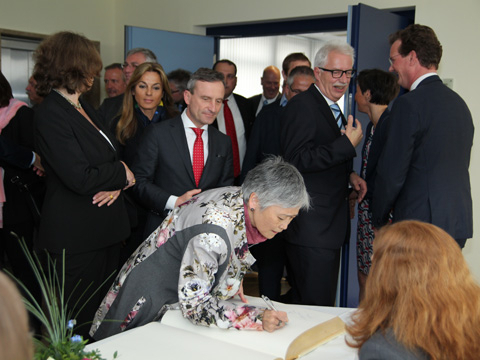 Viele Gäste, wie hier Dr. Akemi Mizuuchi, signieren das Goldene Buch. Im Hintergrund warten (von l. nach r.) Regierungspräsidentin Anne Lütkes, Bundestagsabeordnete Michaela Noll und  Oberbürgermeister Thomas Geisel