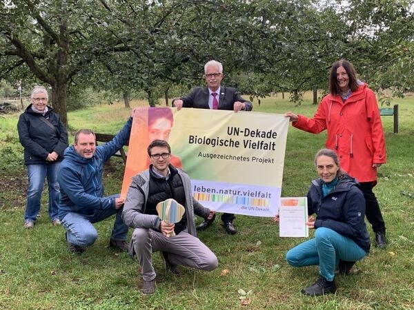 Bild vergrößern: Landrat Thomas Hendele und weitere Personen halten einen Banner mit der Aufschrift: "UN-Dekade. Biologische Vielfalt" zwischen sich in die Hhe.