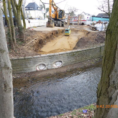 Bild vergrößern: Steinmauer mit in Bau befindende Rohrleitungsanschlssen zur Einleitung von Niederschlagswasser in ein davor flieenden Bach.