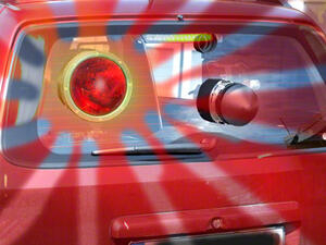 Bild vergrößern: Geschwindigkeitsüberwachungsgerät im Kofferraum eines roten PKWs.
