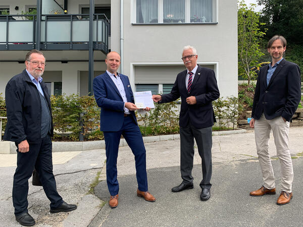Bild vergrößern: Landrat Thomas Hendele berreicht die Auszeichnung an den Baugenossenschaftsvorsitzenden Dominic Johannknecht. Links und rechts die beiden Vorstandsmitglieder der Baugenossenschaft Heinz-Jrgen Rling und Michael Kurosch.