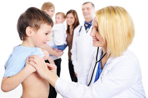 Bild vergrößern: Eine Ärztin untersucht ein Kind mit einem Stethoskop