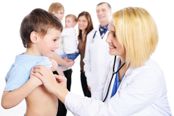 Eine Ärztin untersucht ein Kind mit einem Stethoskop