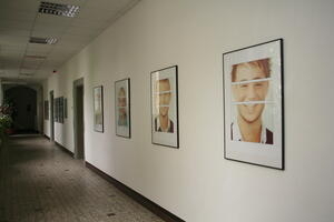 Bild vergrößern: Portraitfotos hängen an einer Wand.
