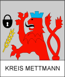 Ein roter Löwe mit blauer Krone, ein Schloss und eine Ähre. Darunter steht in Großbuchstaben "Kreis Mettmann".