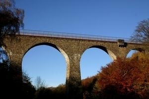 Bild vergrößern: Saulochviadukt - hohe steinerne Bogenbrücke mit rotem Geländer.