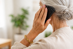 &Auml;ltere Frau telefoniert mit Smartphone, von hinten, graue Haare und Armband sichtbar.
