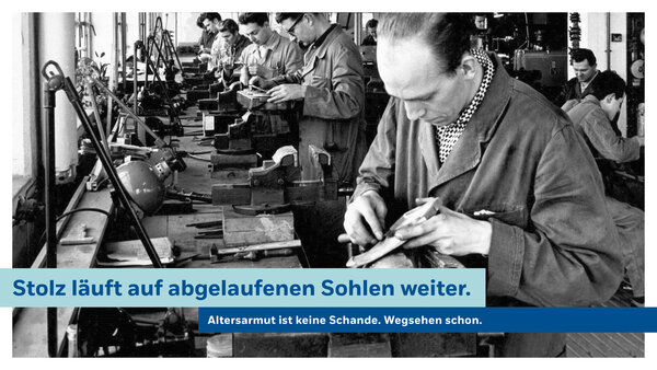 Bild vergr&ouml;&szlig;ern: Plakat gegen Altersarmut. Altes Schwarzwei&szlig;-Foto einer kleinen Fabrikhalle in der M&auml;nner an einer langen Werkbank Schuhe fertigen. Dar&uuml;ber der Spruch: Stolz l&auml;uft auf abgelaufenen Sohlen weiter. Altersarmut ist keine Schande. Wegsehen schon.