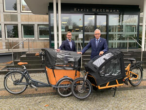 Bild vergrößern: Zwei E-Lastenfahrrädern werden präsentiert von Landrat Thomas Hendele und dem Klimaschutzmanager Dr. Sebastian Kock.